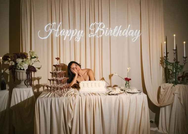 Işıklı Happy Birthday yazısının altında kurulmuş pasta masası